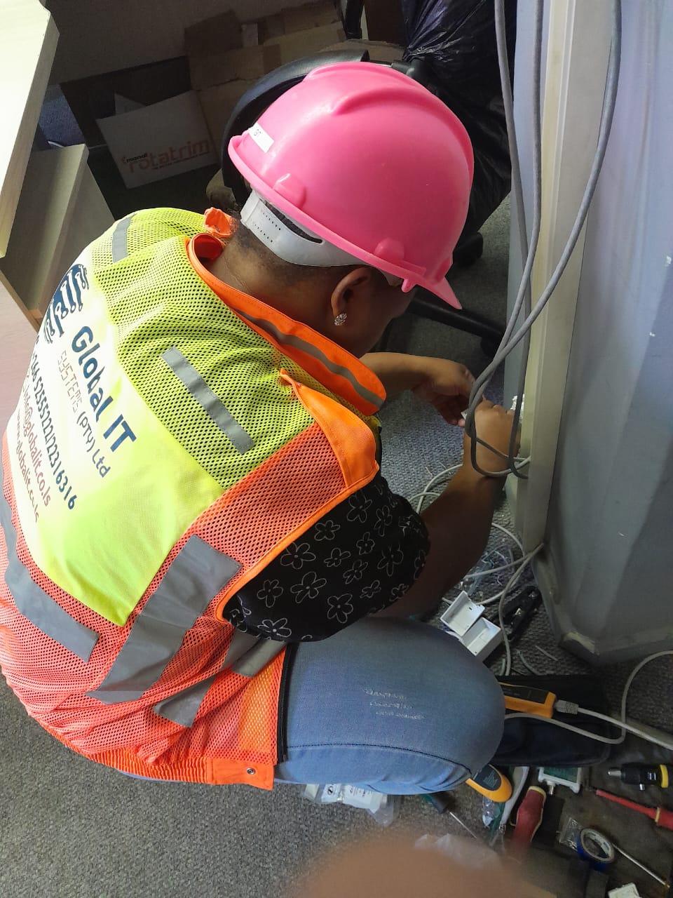 Global IT Systems technician installing structured cabling and a data point on-site